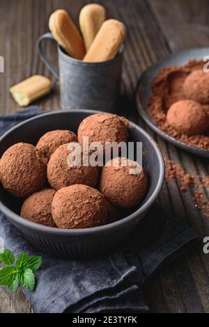 Tiramisu Trüffel in Kakaopulver bedeckt, einfach und schnell keine Backen Dessert aus Mascarpone Käse, Kaffee und Marienkäfer auf rustikalem Holz Stockfoto