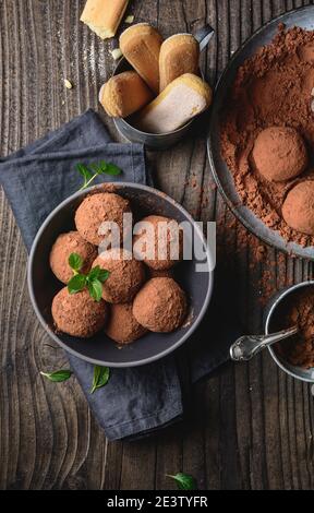 Tiramisu Trüffel in Kakaopulver bedeckt, einfach und schnell keine Backen Dessert aus Mascarpone Käse, Kaffee und Marienkäfer auf rustikalem Holz Stockfoto