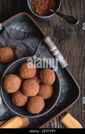 Tiramisu Trüffel in Kakaopulver bedeckt, einfach und schnell keine Backen Dessert aus Mascarpone Käse, Kaffee und Marienkäfer auf rustikalem Holz Stockfoto