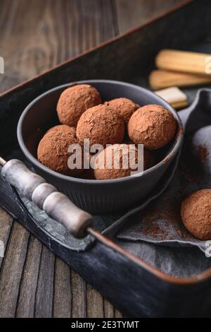 Tiramisu Trüffel in Kakaopulver bedeckt, einfach und schnell keine Backen Dessert aus Mascarpone Käse, Kaffee und Marienkäfer auf rustikalem Holz Stockfoto