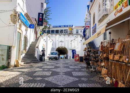 Touristen wandern auf der Rua 5 de Outubro Albufeira Altstadt im Winter im Februar führt der Tunnel zum Strand in Albufeira an der Algarve Portugal Stockfoto