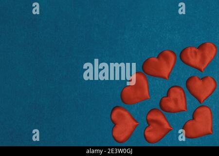 Rote Textilherzen in der Ecke auf blauem Karton Hintergrund. Valentines Day-Konzept, Kopierraum, Flat Lay Stockfoto