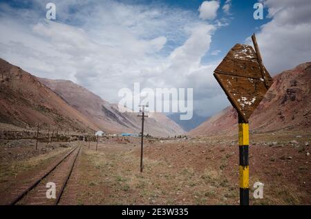 Beschädigtes Eisenbahnstraßenschild in der Nähe der alten verlassenen Eisenbahn in der Wüste in den Anden in der Nähe des Dorfes Puente del Inca, Provinz Mendoza, Argentinien Stockfoto