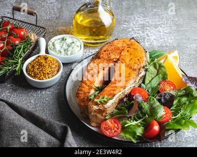 Gebratener Fischsteak Lachs, Forelle mit Salat und Tomaten Stockfoto