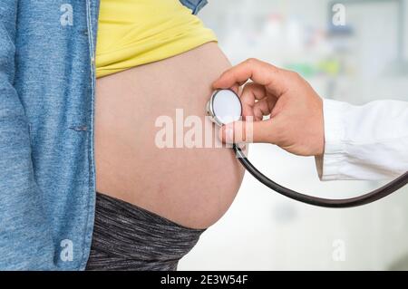 Kinderarzt Arzt mit Stethoskop hört Herzschlag Baby Schwangere Frau - Schwangerschaft Konzept Stockfoto