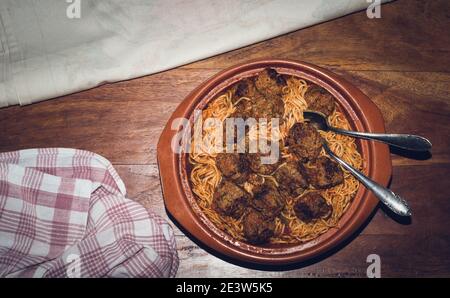 Gericht mit Spaghetti und Fleischbällchen auf einem Holztisch Stockfoto