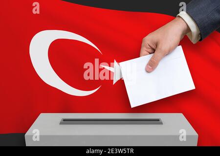 Wahl in der Türkei - Abstimmung an der Wahlurne. Die Hand des Menschen stellt seine Stimme in die Wahlurne. 3D-Darstellung. Stockfoto