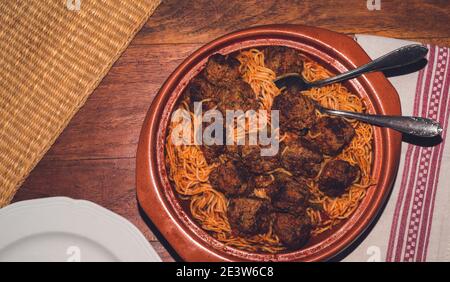 Gericht mit Spaghetti und Fleischbällchen auf einem Holztisch Stockfoto