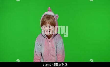 Junge kleine blonde Kind 5-6 Jahre alt im Einhorn Kostüm weinen mit Tränen auf Chroma-Key-Hintergrund. Portrait von Kind Mädchen Animator im Einhorn Pyjamas. Speicherplatz kopieren Stockfoto
