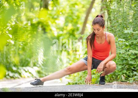 Läuferin Frau Stretching Bein Laufen Workout Run Mädchen tun Beine dehnt im Sommer Park. Asiatischer Athlet Aufwärmen Vorbereitung vor dem Training. Stockfoto