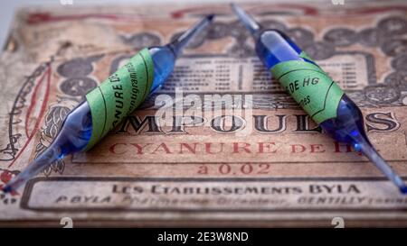 Nahaufnahme von alten blauen Cyanid-Ampullen mit grünen Aufklebern auf einer alten pharmazeutischen Box. Übersetzung: hg Cyanid-Ampullen. Retro-Stil. Ehemaliger Pharmac Stockfoto