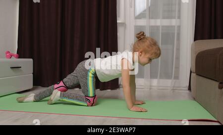 Kinder Mädchen in Sportbekleidung machen Sport Übungen Aufwärmen Cardio. Fit Kleinkind Training Gymnastik Fitness Stretching Workout auf Matte. Gesunder Lebensstil, aktive Freizeit zu Hause. Kopierbereich Stockfoto