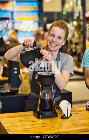 Weibliche Barista gießt Kaffee durch melitta Filter Stockfoto