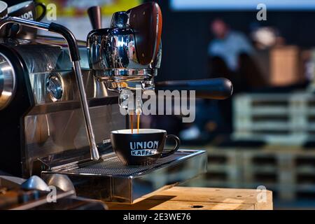 Frischer Kaffee tropft vom Portafilter der Kaffeemaschine in die Tasse. Stockfoto