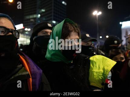 Warschau, Warschau, Polen. Januar 2021. Eine Demonstratorin, die eine schützende Gesichtsmaske und eine grüne Bandana über dem Kopf trägt, als Symbol für die freie Wahl der Abtreibung, wie sie von Pro-Choice-Aktivisten in argentinien verwendet wird, wird bei einem Protest gegen die Regierung am 20. Januar 2021 in Warschau, Polen, gesehen. Hunderte von Demonstranten aus verschiedenen sozialen und wirtschaftlichen Gruppen gingen in einer regierungsfeindlichen Demonstration auf die Straße. Unternehmer und Taxifahrer demonstrierten gegen den Mangel an wirtschaftlicher Unterstützung und die laufende Sperrung, während Strajk Kobiet (All-Polens Women Strike) sich Anarchisten anschloss und links Stockfoto