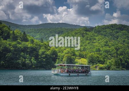 Plitvicka Jezera, Kroatien, Juli 2019 Fähre mit Touristen auf türkisfarbenem See. Nationalpark Plitvicer Seen UNESCO Weltkulturerbe Stockfoto