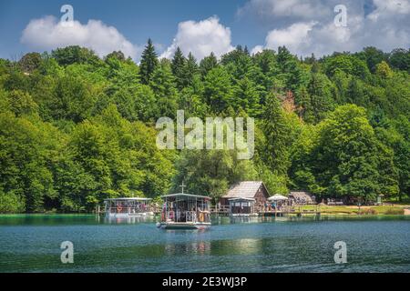 Plitvicka Jezera, Kroatien, Juli 2019 Fähre mit Touristen Abfahrt kleinen Hafen, um den See zu überqueren. Nationalpark Plitvicer Seen UNESCO Weltkulturerbe Stockfoto