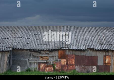 Alte verwitterte Holzhütte, grau überzogene Holz-Boarding-Hütte Wand, geflickte Bretter, verrostete Metallplatten, rostige Farbstruktur, Moltescape Panorama Stockfoto