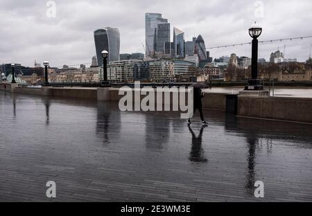 London, Großbritannien. Januar 2021. Ein Mann mit Regenschirm, der am 20. Januar 2021 in London, Großbritannien, den Potters Fields Park entlang läuft, wo er normalerweise häufig für Lebensmittelfestivals und andere Veranstaltungen genutzt wird. Met Office Prognosen der einzige sonnige Tag in London in den nächsten 7 Tagen sollte am Freitag Januar 22 sein Credit: May James/ZUMA Wire/Alamy Live News Stockfoto