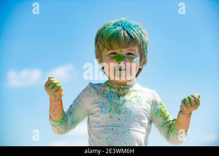 Kinder Holi Festival der Farben.. Bemaltes Gesicht von lächelndem Kind. Kleiner Junge spielt mit Farben Stockfoto