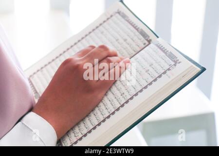 Nahaufnahme der Hand beim Lesen des Heiligen Quran in der Moschee. Selektiver Fokus. Stockfoto