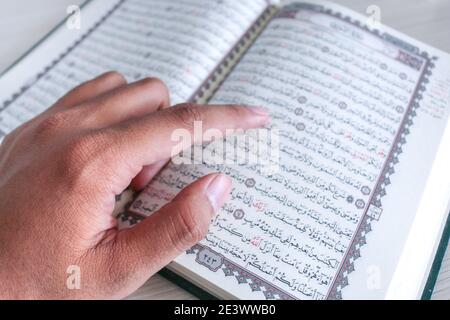 Nahaufnahme der Hand beim Lesen des Heiligen Quran in der Moschee. Selektiver Fokus. Stockfoto