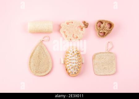 Bad-Accessoires, Naturlöffelschwamm, Holzbürste auf rosa Hintergrund. Zero Waste und plastikfreies Konzept, nachhaltiges Bad und Lifestyle Stockfoto
