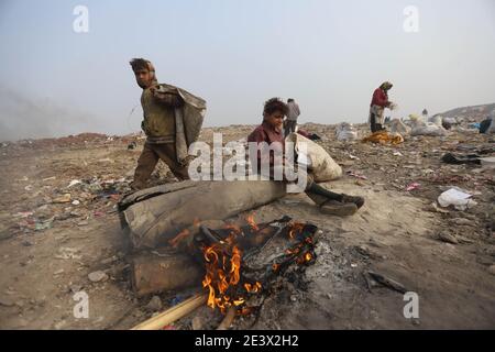 Neu Delhi, Indien. Januar 2021. Ein junger Fetzen-Picker sitzt am kalten Morgen neben einem Feuer an der Bhalswaer Müllhalde. Quelle: Vijay Pandey/dpa/Alamy Live News Stockfoto