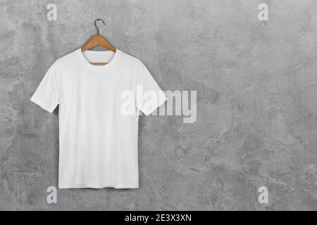 Weiß Blank Baumwolle T-Shirt Hängend Center Grau Beton Leere Wand Hintergrund mit Beschneidungspfad Stockfoto