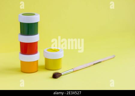 Farbenfrohe, lebendige Dosen aus Gouachefarbe und Pinsel. Bunte Farbdosen Set. Hintergrund wird gemalt. Eine Reihe von Acrylfarben in Gläsern für den Künstler. Kopieren Stockfoto