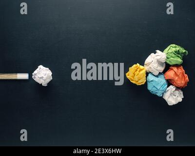 Cue zielt auf Papierkugeln auf einem Tafelhintergrund, Konzeptbild für neue Ideen, Kreativität und Teamwork Stockfoto