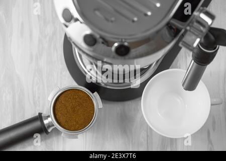 Draufsicht auf einen Portafilter einer Kaffeemaschine, gefüllt mit gemahlenem Kaffee, bevor Sie einen Espresso zubereiten. Stockfoto