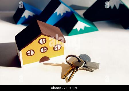 Spielzeug Holzhaus, Holzberge und Schlüssel. Verkauf oder Kauf, Mietkonzept. Immobilien-Service auf dem Markt. Stockfoto