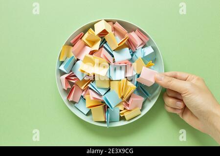 Los ziehen. Gefaltete bunte Papiere in Schüssel Stockfoto