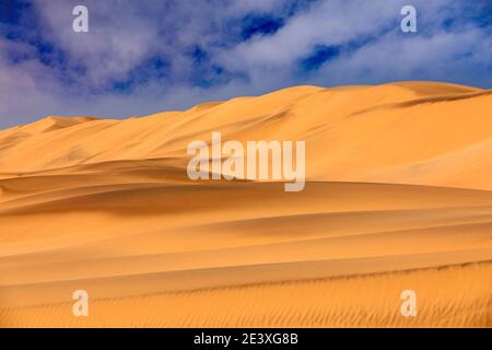 Landschaft in Namibia, Afrika. Reisen in der Wüste Namibias. Gelbe Sandhügel. Namib Wüste, Sanddünenberg mit schönem blauen Himmel mit Weiß Stockfoto