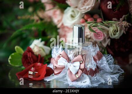 Hochzeit Zubehör für die Braut und Bräutigam: Ein Bouquet von roten, rosa und weißen Rosen, ein boutonniere, goldene Eheringe, ein Spitzengewand mit Schleife, perf Stockfoto