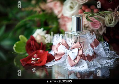 Hochzeit Zubehör für die Braut und Bräutigam: Ein Bouquet von roten, rosa und weißen Rosen, ein boutonniere, goldene Eheringe, ein Spitzengewand mit Schleife, perf Stockfoto