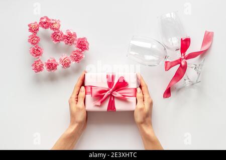 Rote Geschenkbox in Frauenhand - Valentinstag Feier. Draufsicht Stockfoto
