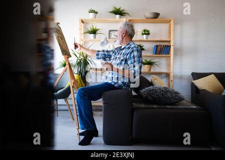 Stattliche reifer Mann Künstler malt auf Leinwand malen auf der Staffelei Stockfoto