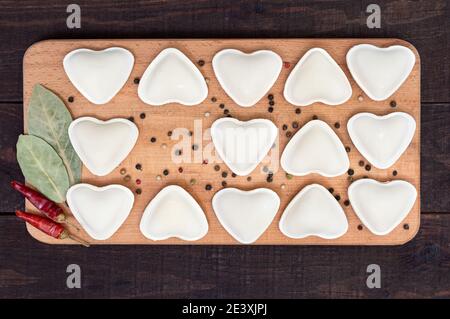 Herzförmige Knödel auf einem Holzbrett bereit zum Kochen. Draufsicht. Stockfoto