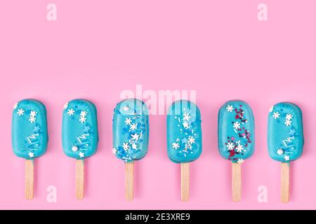 Leckeres und erfrischendes Eis auf Stöcken. Blaue Minze Eis-Eis-Eis-Eis-Eis auf pastellrosa Hintergrund. Minimales Sommerkonzept. Flach liegend. Stockfoto