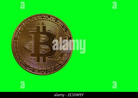 Einzelne wertvolle goldene Bitcoin auf grünem Hintergrund Stockfoto