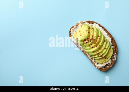Avocado-Toast auf Roggenbrot mit geschnittenem Avocado auf einem hellblauen Hintergrund, ein gesunder Avocado-Toast in einer Oberansicht Stockfoto