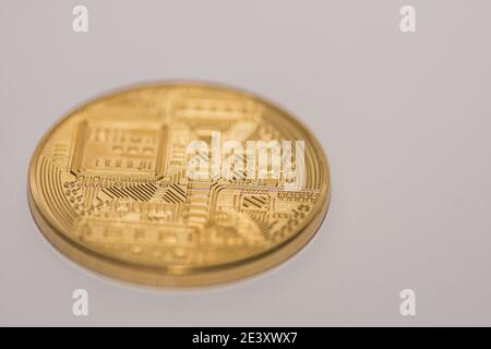 Einzelne Bitcoin liegt mit der Rückseite auf einem Licht Grauer Hintergrund Stockfoto