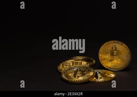 Stapel von golden glänzenden wertvollen Bitcoins mit einem schwarzen Hintergrund Ansicht rechts Stockfoto