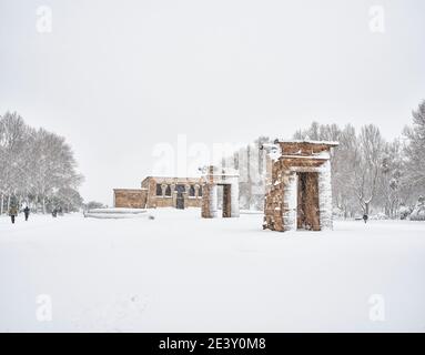 Bürger, die den Cuartel de la Montana Park inmitten von Schneesturm mit dem Tempel von Debod im Hintergrund überqueren. Madrid, Spanien. Stockfoto