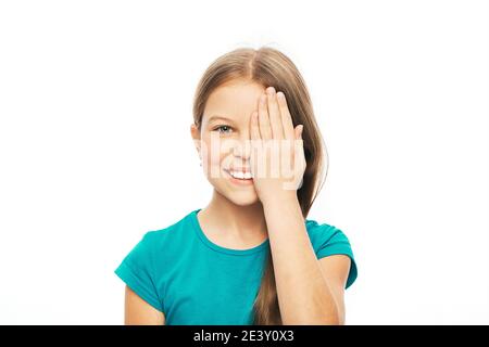 Lächelndes Kind, das Auge mit der Hand schließt, um das Sehen zu überprüfen, isoliert auf weißem Hintergrund. Vision Test Konzept für Kinder Stockfoto