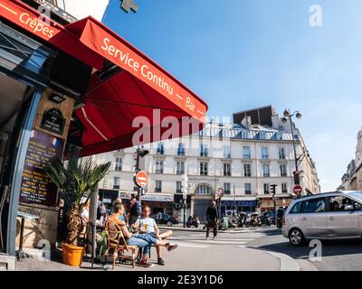 Paris, Frankreich - 20. Mai 2018: Ultra-Weitwinkelansicht des französischen Haussmannschen Gebäudes in der Rue du Faubourg Saint Denis auf der Terrasse des Cafés und der Kreuzung Stockfoto