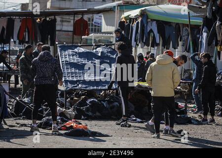 Bagdad, Irak. Januar 2021. Irakische Händler inspizieren den Schauplatz eines zweifachen Selbstmordattentats auf einem Straßenmarkt, der gebrauchte Kleidung im Zentrum von Bagdad verkauft. Mindestens 28 Menschen wurden bei einem zweifachen Selbstmordanschlag getötet und mehr als 70 verletzt, der auf das geschäftige Geschäftsviertel Bab Al Sharqi abzielte, nachdem sich zwei Selbstmordattentäter bei der Verfolgung durch Sicherheitskräfte in die Luft gesprengt hatten. Quelle: Ameer Al Mohammedaw/dpa/Alamy Live News Stockfoto