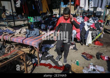 Bagdad, Irak. Januar 2021. Ein Iraker kommt an Blutflecken vorbei, als in einem Straßenmarkt im Zentrum von Bagdad ein zweigleisiger Selbstmordanschlag auf die Straße ging, der gebrauchte Kleidung verkauft. Mindestens 28 Menschen wurden bei einem zweifachen Selbstmordanschlag getötet und mehr als 70 verletzt, der auf das geschäftige Geschäftsviertel Bab Al Sharqi abzielte, nachdem sich zwei Selbstmordattentäter bei der Verfolgung durch Sicherheitskräfte in die Luft gesprengt hatten. Quelle: Ameer Al Mohammedaw/dpa/Alamy Live News Stockfoto